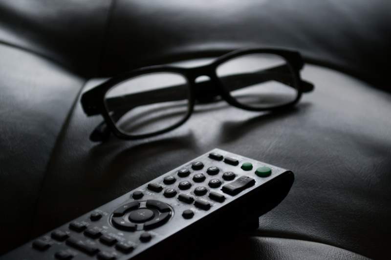 glasses and TV remote on couch