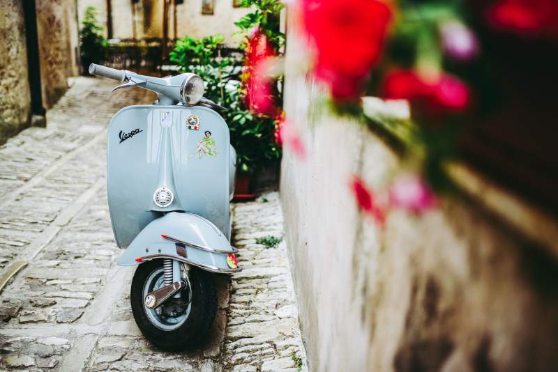 powder blue vespa parked in the street