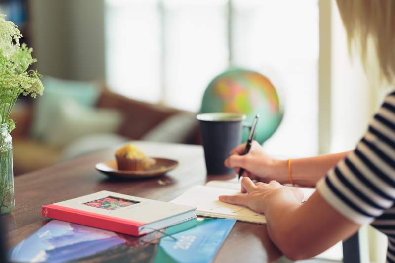 woman sitting at desk writing in diary