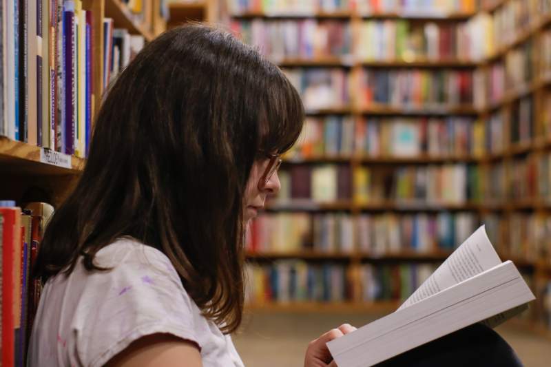 woman reading book in library