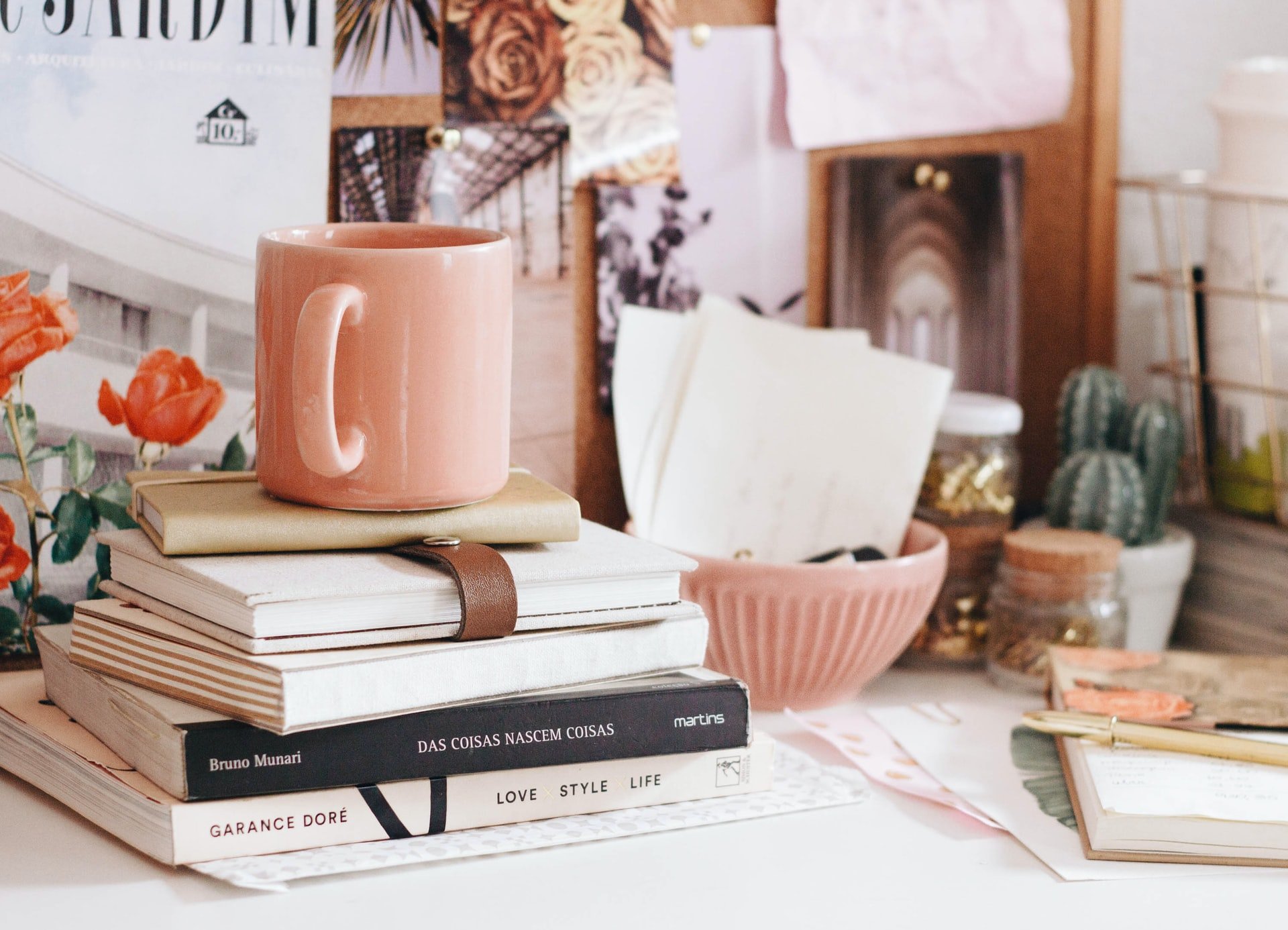 books in portuguese on a desk with notebooks and mug