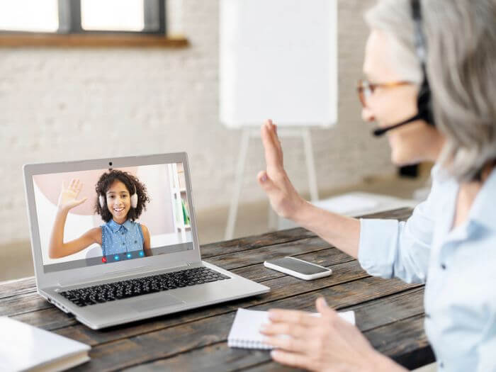 Woman waving hello to online student