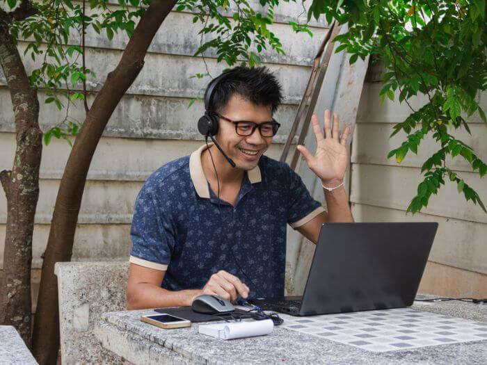 male online teacher waving hello to studen