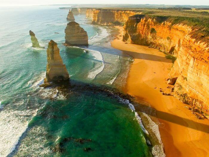 a beach with cliffs and water, Straya