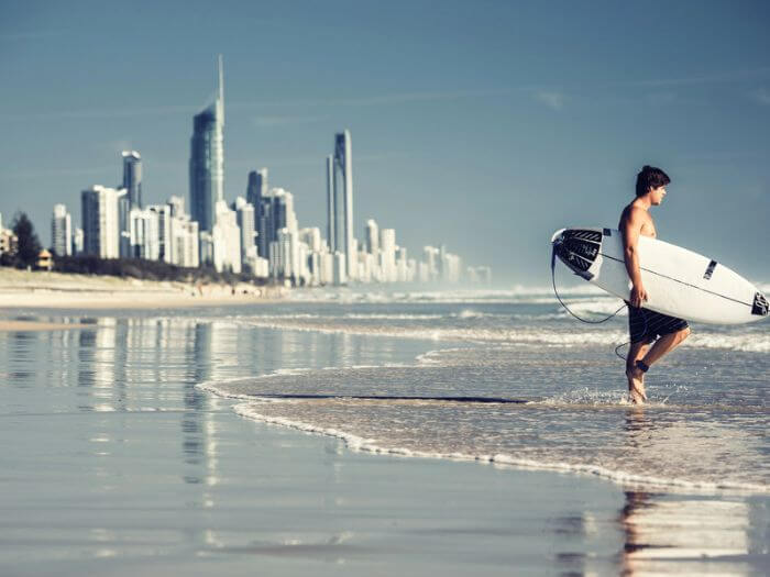 a man carrying a surfboard on a beach