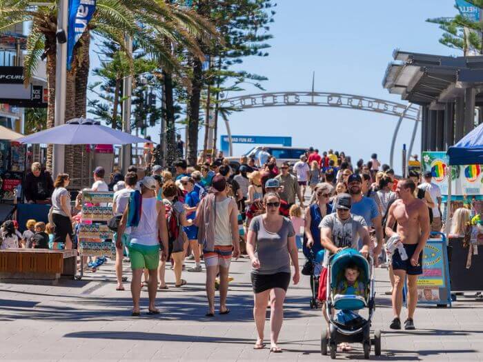 a group of people walking on a sidewalk, everyone and their mum