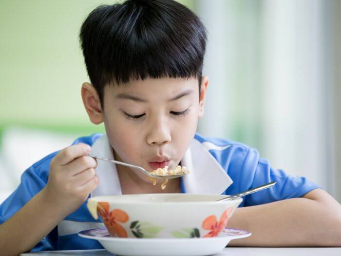 Chinese boy eating from bowl 