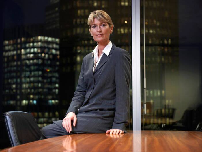 Female CEO sitting on a desk