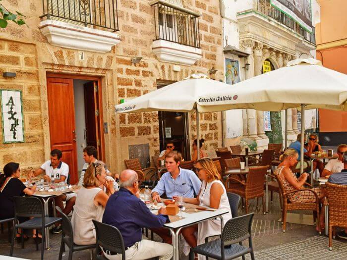 People at the terrace of a restaurant in Cadiz, Spain