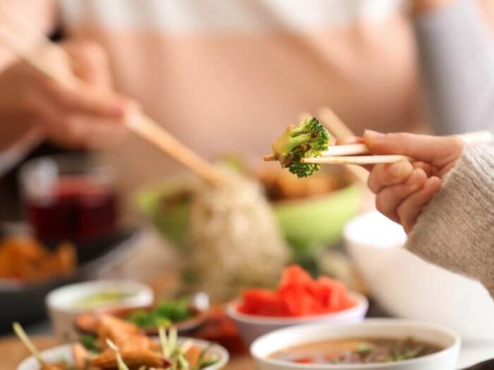 People eating Chinese food together with chopsticks