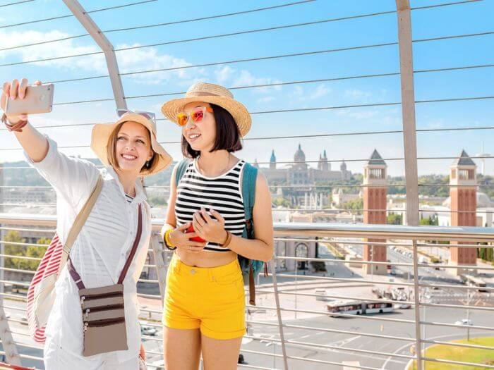 Tourists taking a selfie at the Plaça d'Espanya viewpoint in Barcelona, Spain 