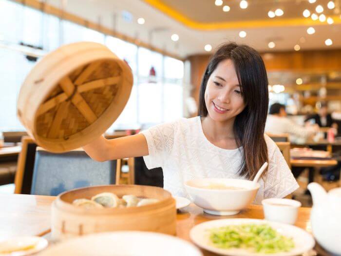 Woman eating healthy Chinese food at a restaurant 