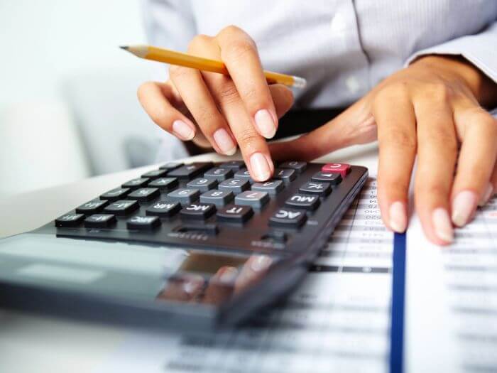 Woman looking at accounts with a calculator