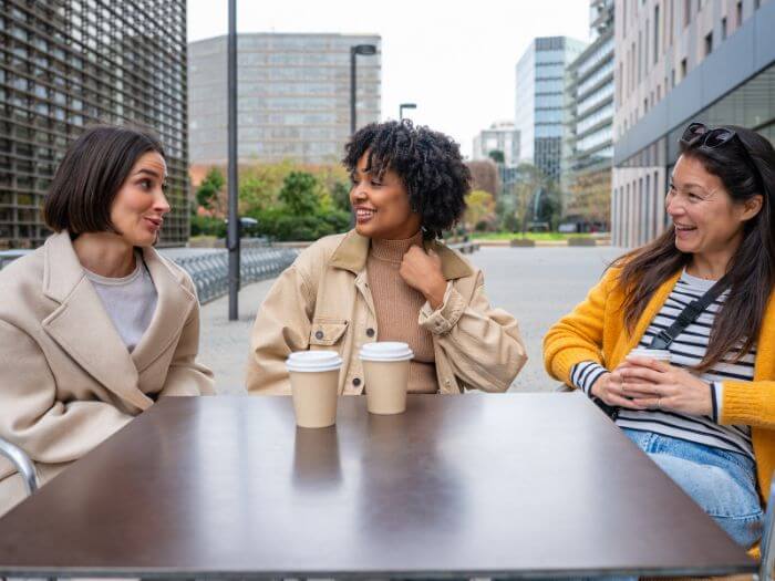 a group of women sitting at a table with coffee cups