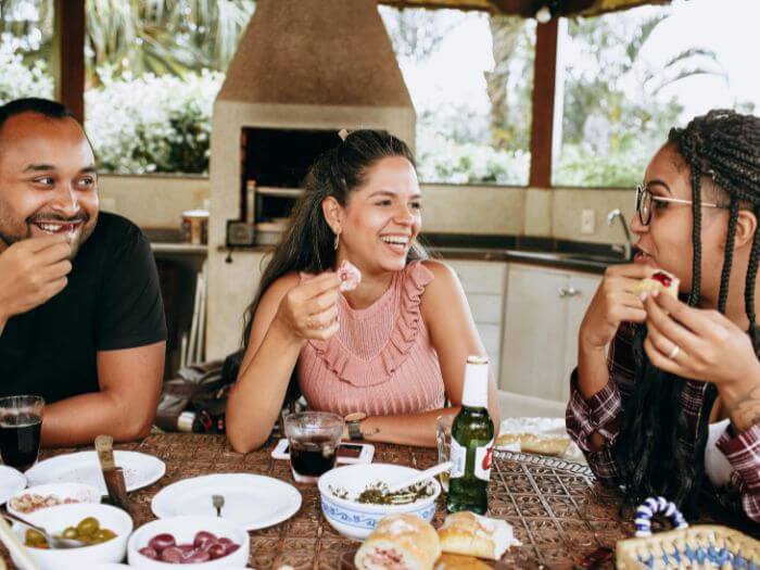 a group of people sitting at a table eating food
