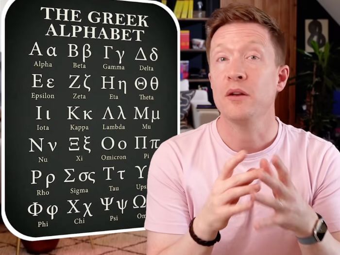 Olly Richards next to Greek alphabet