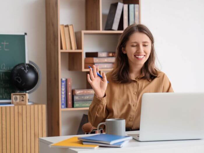 a woman sitting at a desk with a laptop and a cup